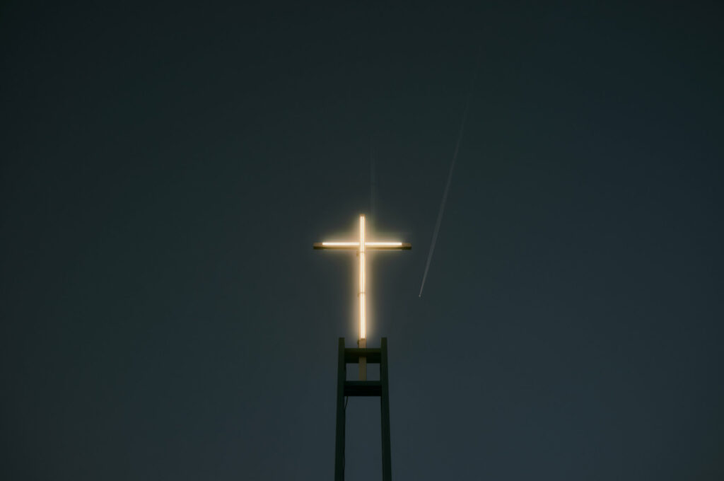 Strahlendes Neonkreuz auf einem Gerüst